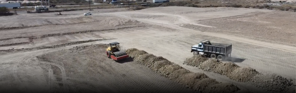 Maquinaria en un terreno haciendo la superficie de la construcción para iniciar el proyecto industrial