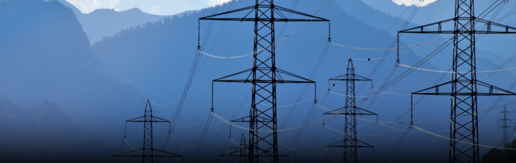 Postes de luz en un terreno con cerros de fondo